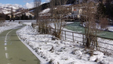 Castel di Sangro the green of the cycle path and the white of the snow on the riverside a unique mountain landscape