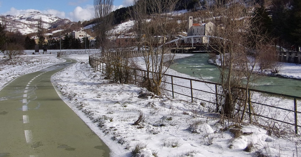 Castel di Sangro the green of the cycle path and the white of the snow on the riverside a unique mountain landscape