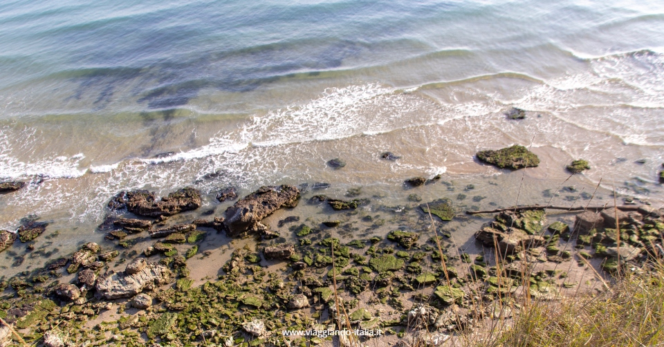 Sai dove si trova questa "spiaggia primordiale", acqua trasparente e scogliera alta sul mare?